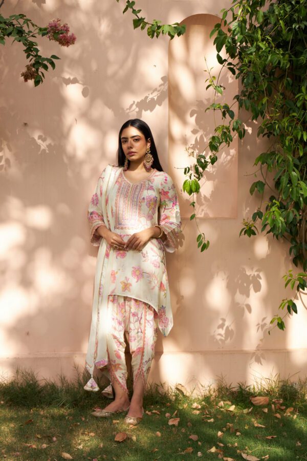 Discover elegance in our cream floral printed tunic with a chic C-cut hemline, paired effortlessly with tulip pants for a modern twist. Complete your ensemble with a soft organza dupatta adorned with exquisite hand embroidery and delicate lace work. Perfect for any occasion, this ensemble combines traditional charm with contemporary flair, ensuring you stand out with grace and sophistication. Ideal for those who appreciate fine craftsmanship and timeless style.